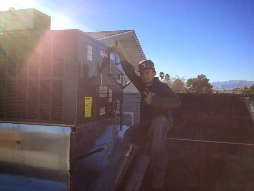 HVAC technician performing HVAC Inspection on a rooftop unit in Donna